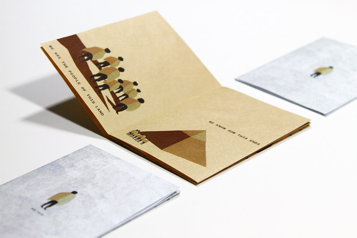 Image of zine on brown paper and textured white paper