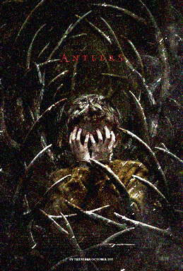A young boy covering his face with his hands is surrounded by antlers.